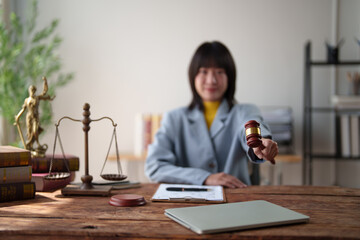 Female legal professional holding a gavel. Symbolizing authority and legal proceedings. With scales...