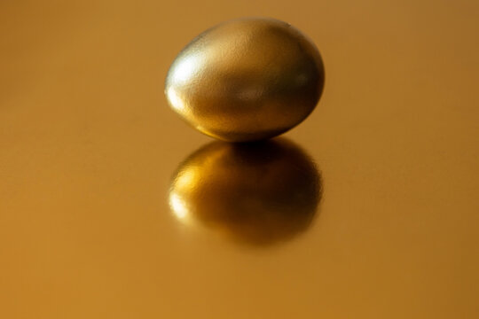 golden egg on golden background with copy space. concept of luxury premium Easter, income and business investment