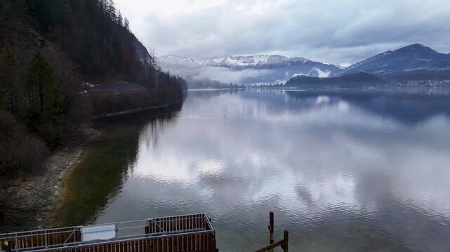 Mountain lake aerial view with pier and snowcapped peaks