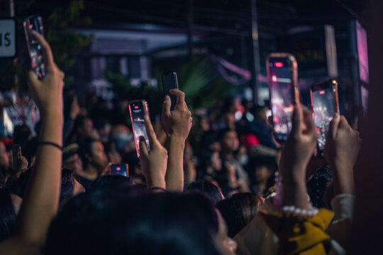 Hands of spectators pointing their smartphones to photograph the ogoh-ogoh event