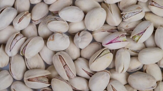 Crunchy pistachios in shells. Detail of salted pistachios with shells and kernels. Closeup photograph of salted pistachios in shells with visible kernels and salt crystals