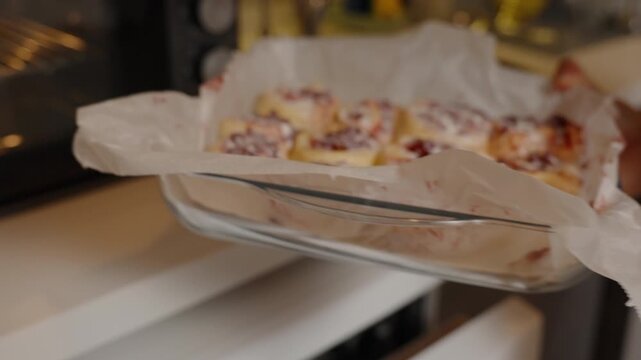Placing Cherry-Filled Dough Rolls into a Preheated Oven, Ready for Baking.
