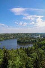 Obraz premium Aulanko Nature Reserve in Hämeenlinna, Finland. Vertical view from the old observation tower. Summer landscape with a lake and dense forest