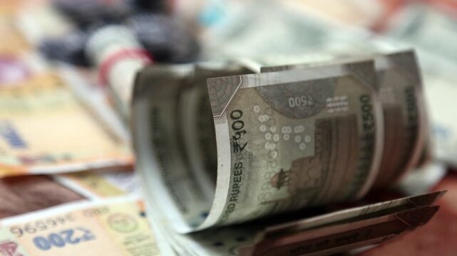 Closeup 4k video of Indian 500 rupee notes stacked and rolled. Financial concept showing cash money, savings, economy, and wealth in India.