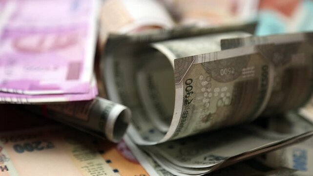 Closeup 4k video of Indian 500 rupee notes stacked and rolled. Financial concept showing cash money, savings, economy, and wealth in India.