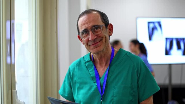 Senior surgeon examining x ray before smiling at camera