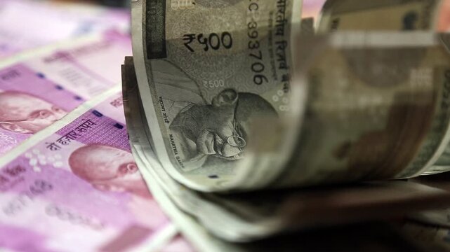 Closeup 4k video of Indian 500 rupee notes stacked and rolled. Financial concept showing cash money, savings, economy, and wealth in India.