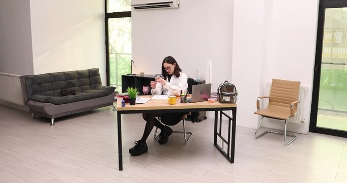 Woman uses compass and pencil to create precise technical drawing. Female sits at table by laptop and draws smooth circles as part of draft in office