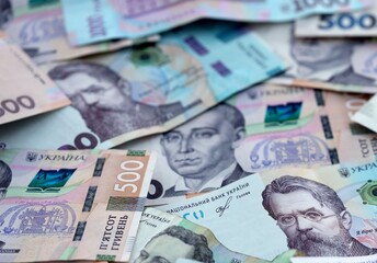 Fototapeta premium Ukrainian hryvnia money bills pile on table. Ukraine banknotes of UAH currency close up.
