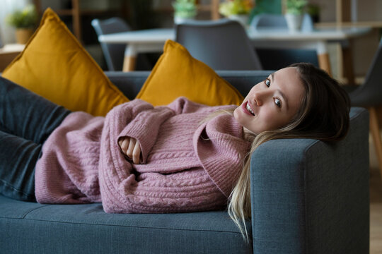 Portrait of smiling woman relaxing on sofa at home