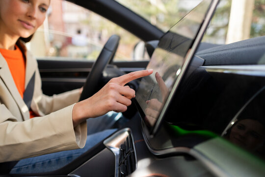 Person navigating touch screen GPS in car interior