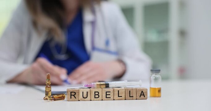 Wooden blocks spell word Rubella near ampoules and patient chart on desk. Doctor woman records immunity check updating prenatal vaccination advice