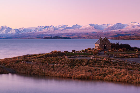 Lake Tekapo, New Zealand, under purple dusk skies. On the right is the Church of the Good Shepherd 