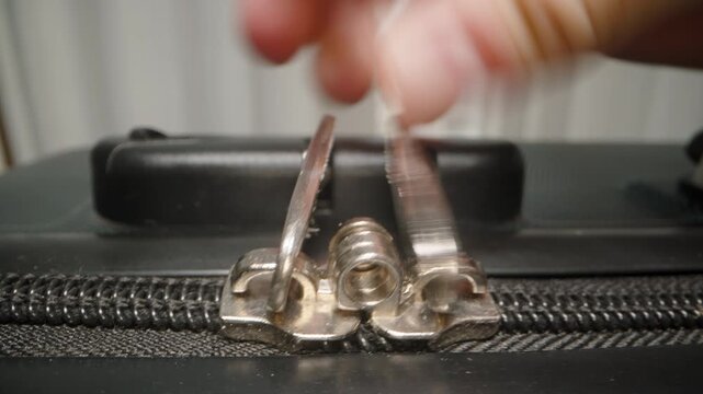 A Hand locks the zipper tabs of a suitcase, completing the packing process and anticipating the start of a relaxing getaway.