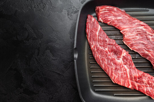 Closeup raw beef premium steak on grill pan showing texture and grain, uncooked meat ready for searing grilling or barbecue cooking