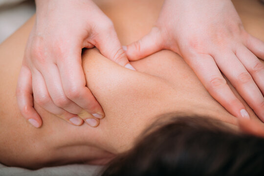 Relaxing foot massage, hands of a female massage therapist massaging female client&rsquo;s foot.