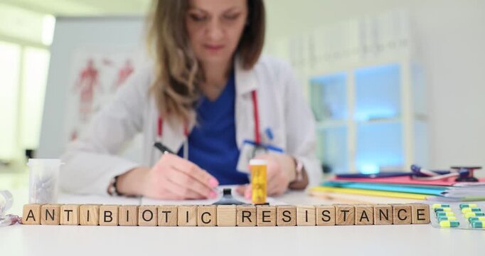 Wooden cubes arranged on table form phrase Antibiotic Resistance. Doctor documents recommendations intended to guide proper treatment behavior