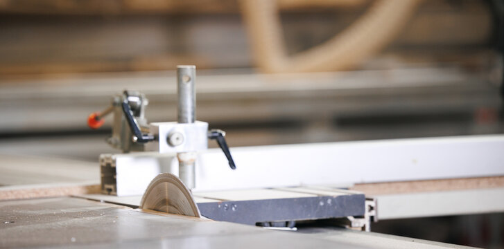 Closeup of wood cut table with electric circular saw for chipboard for furniture production. Professional carpenter cutting wooden board at sawmill