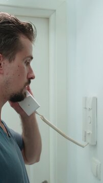 Man answer the intercom and push the button