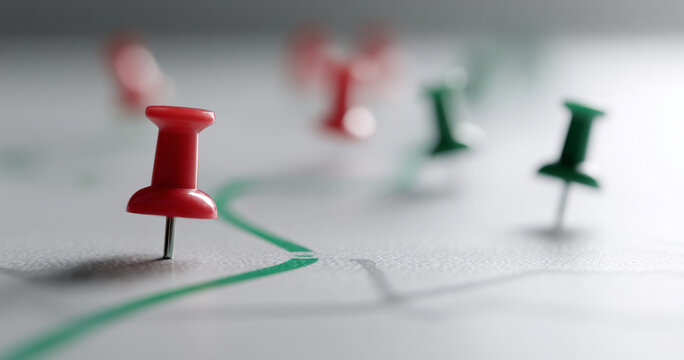 Red and green push pins on map