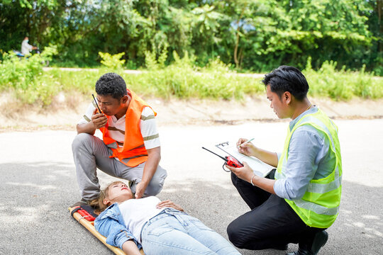 Ambulance and rescue paramedic helping woman driver from car accident on road