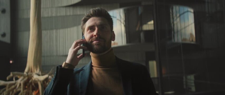 Selfassured man in casual formal attire conducting important business transaction in contemporary atrium