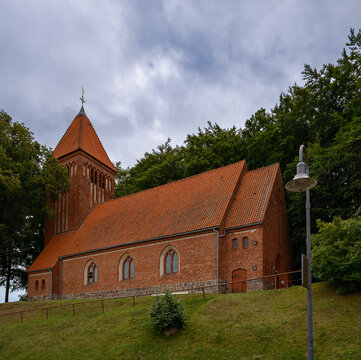 Auf einem H&uuml;gel &uuml;ber der Stadt thront die denkmalgesch&uuml;tzte Dorfkirche von Binz - Ansicht von Westen, Inschriften retuschiert
