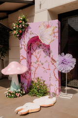 Obraz premium Fantasy Theme Party Decor with Mushroom and Butterfly Cutouts, Floral Wall Display, and Pastel Accents for Festive Celebration