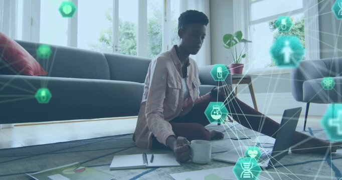 Animation of network of connections with icons over african american woman learning