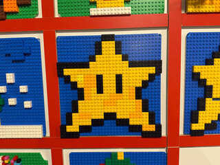 Obraz premium Pixelated yellow star lego mosaic on blue background