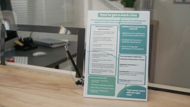 No people close-up of information leaflet with work visa application instructions at customer service counter at foreign country embassy, consulate or government agency