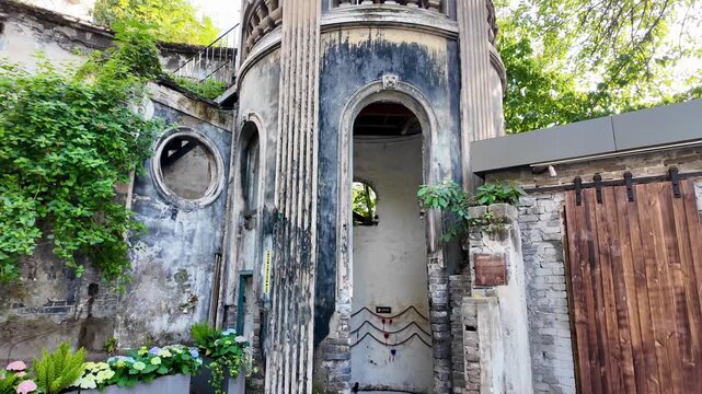 Slow motion video filming aged stone building exterior with tall arched doorway and fluted columns, weathered walls with peeling texture at Chongqing&rsquo;s No. 1 Chinese Traditional Medicine Hospital