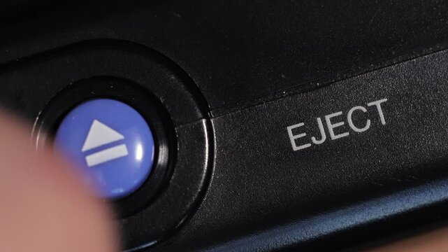 Diagonal close up shows blue eject button on left and white eject text on right