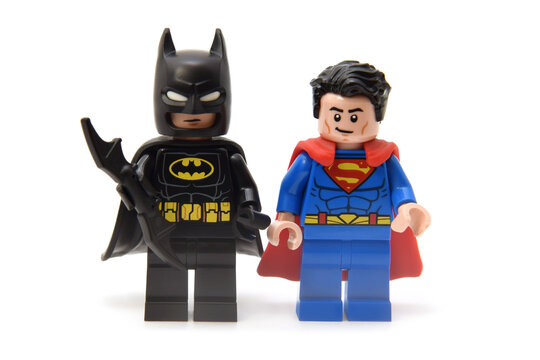 Lego minifigures of Superman in costume with red coat and batman in black coat with bat. Editorial illustrative image of popular children toys and comic heroes.