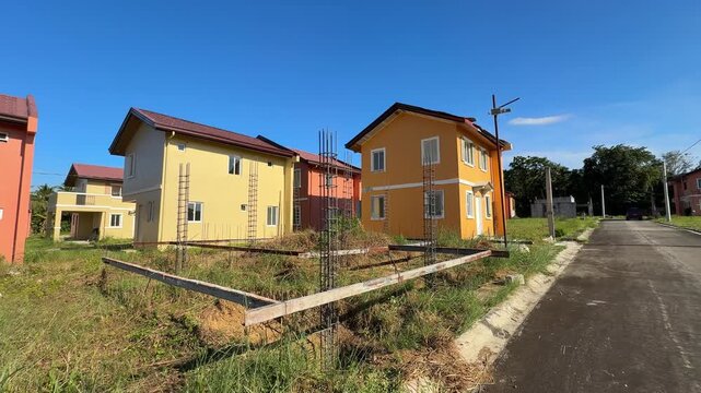 Ground level view showing ongoing house construction beside clean, finished homes in a well-developed village at Camella Homes Alfonso Cavite Philippines