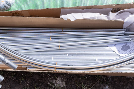 Greenhouse kit unpacking metal pipes and covering material for assembly
