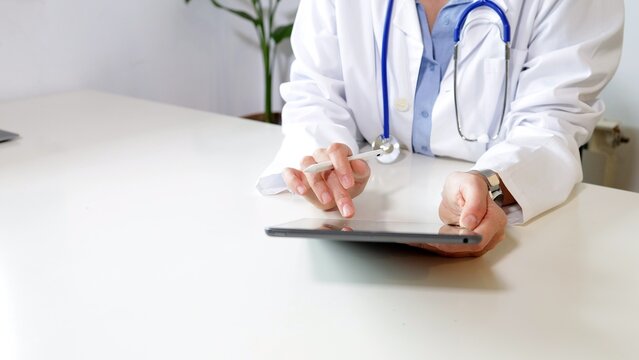 Doctor working with a digital tablet and stylus, accessing healthcare information and managing patient data for modern medical practices and telehealth services