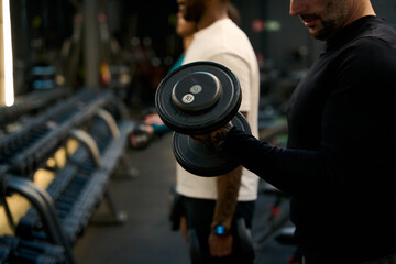 Obraz premium Man training bicep curl with dumbbell at gym