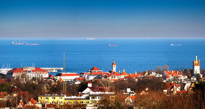 Wide panorama of Sopot city coastline featuring Grand Hotel, lighthouse and cargo ships on the Baltic Sea.