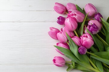 Obraz premium Beautiful pink and purple tulips bouquet on white wooden surface, top view, springtime floral arrangement