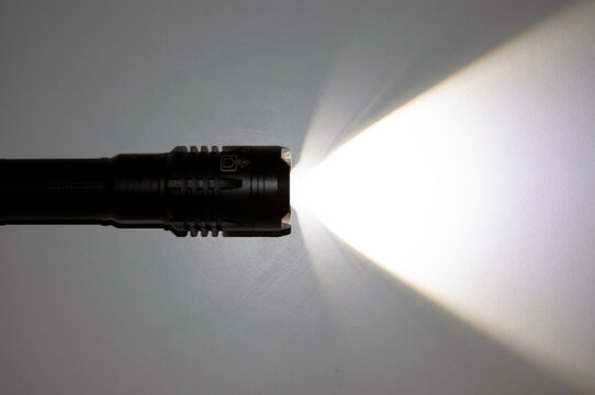A spotlight on the wall. A torch with a ray of light. Flashlight. Black torch lights with copy space.