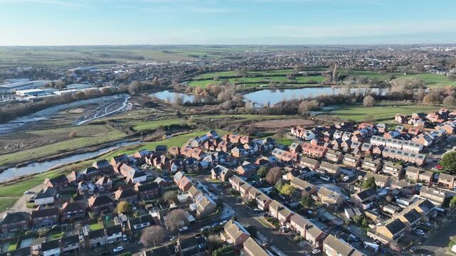 Aerial drone flight over Barton Seagrave towards countryside and farmland on clear winter day Northamptonshire