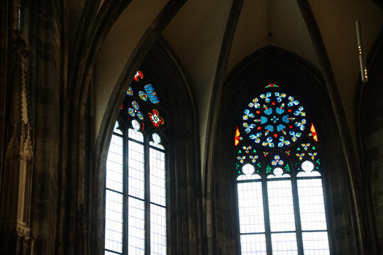 Elegant Gothic church interior in Vienna featuring colorful stained glass windows and dramatic arches. Ideal for themes of history, architecture, spirituality, and European travel.