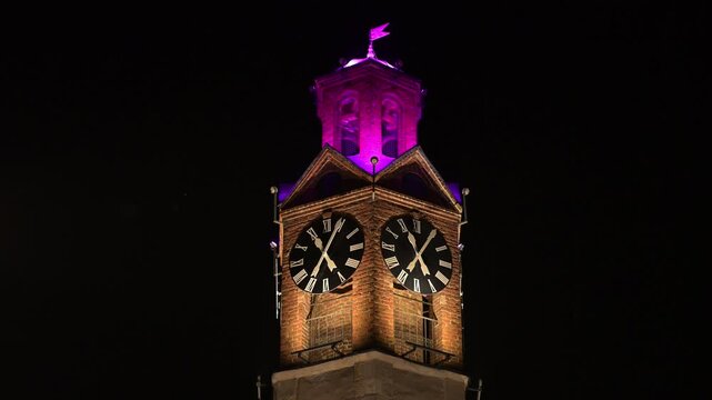 Clock tower on minaret by mosque at night. Historic sahat kula. Traditional Islamic architecture. 