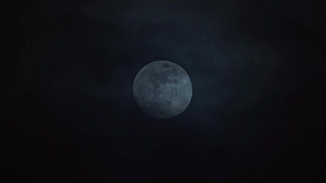 Clouds passing infront of large full moon