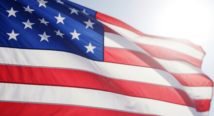 Obraz premium American flag waving in wind against clear blue sky patriotic background