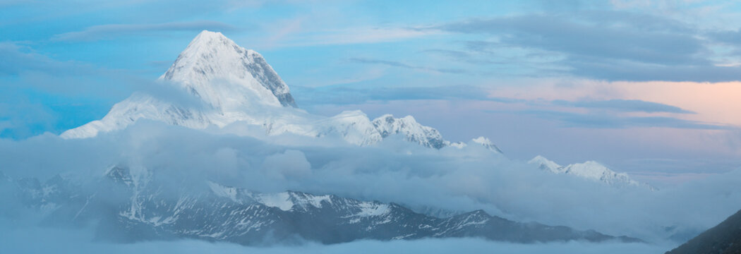 Majestic Mount Gongga (Minya Konka) rising above cloud sea at dawn, Sichuan, China &mdash; iconic Himalayan peak with snow-capped summit and layered alpine landscape