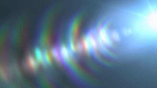 Slow pan tracking shot of colorful lens flare reflections shifting across dark studio background with rainbow prism highlights and soft diffuse glow