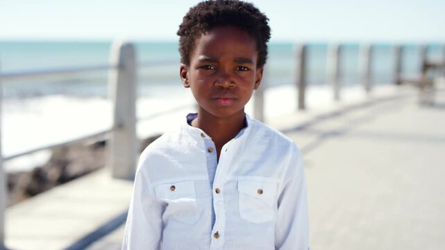 Beach, face and sad with black kid outdoor for holiday, travel or vacation frustration. Miserable, moody and unhappy with African child on promenade for sightseeing or tourism disappointment