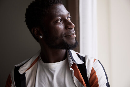 Contemplative male tech expert looking away through window